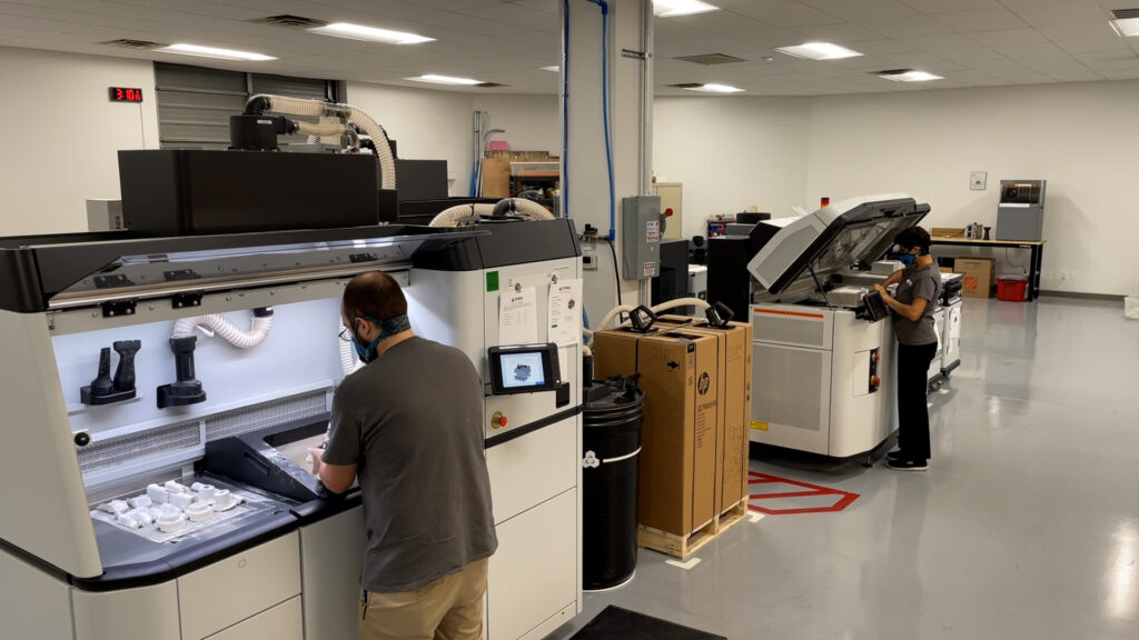 A3D Manufacturing staff on the shop floor post-processing parts from an HP 3D printer