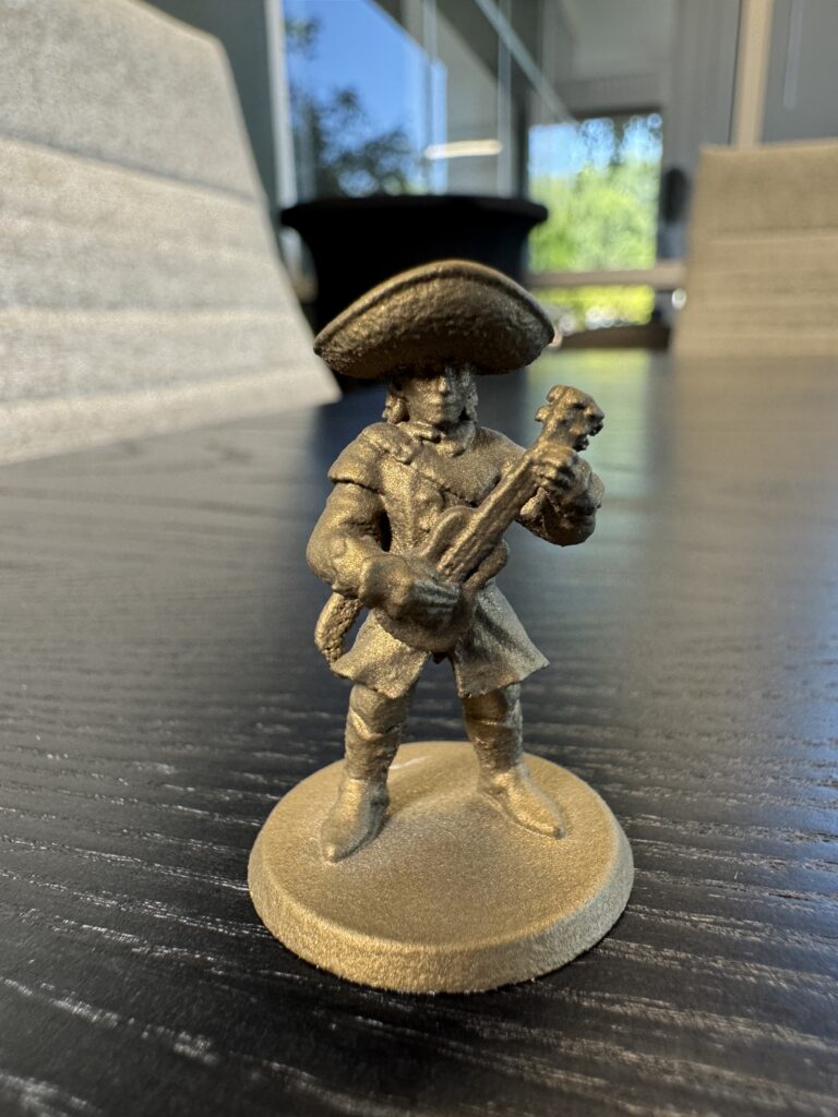 Front-on view of the finished mini, showing how the gold catches light across the brim and instrument.